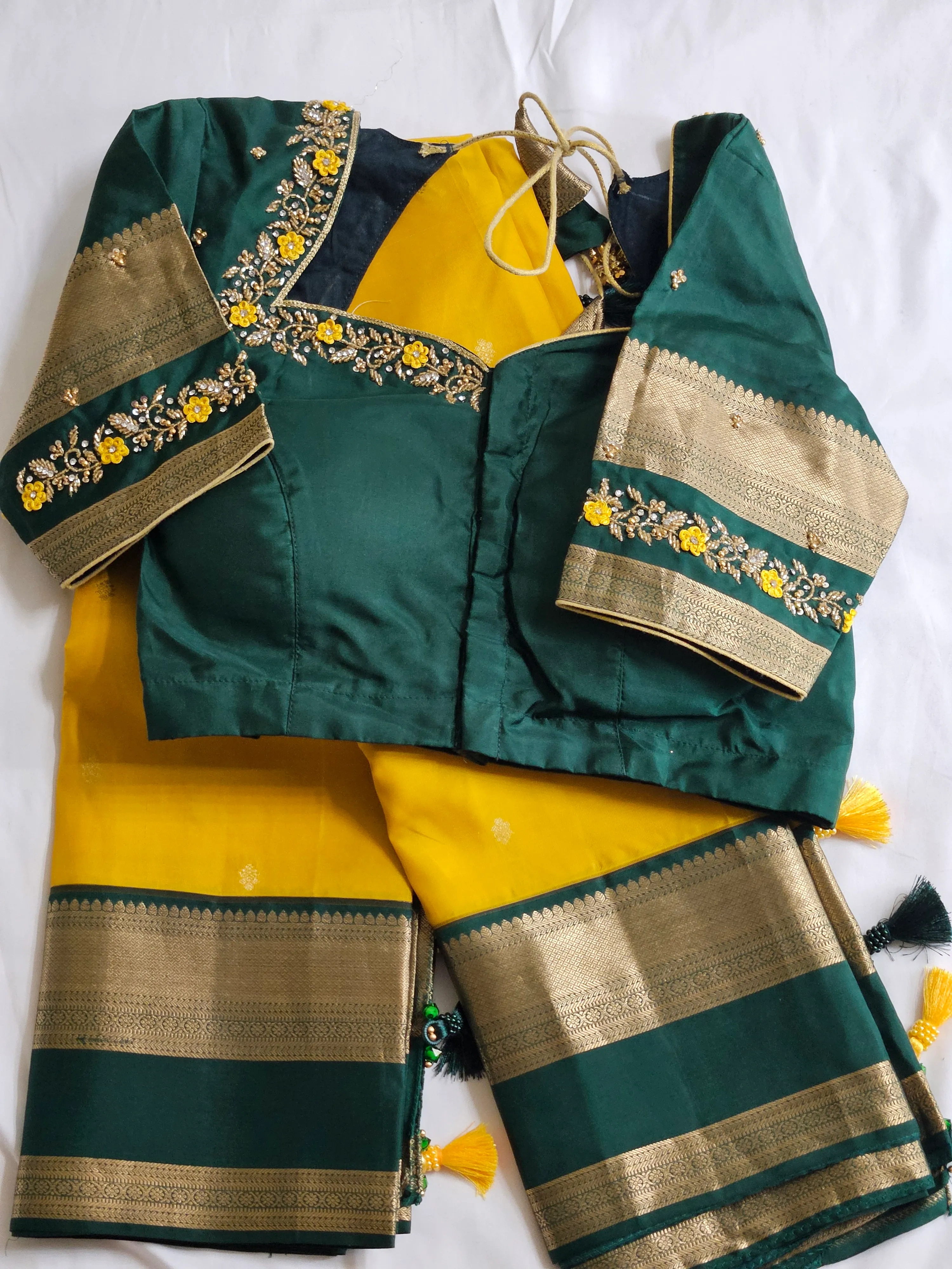 Handwoven pure Kanchipuram silk saree in yellow with gold and silver zari borders, paired with a green embroidered blouse.