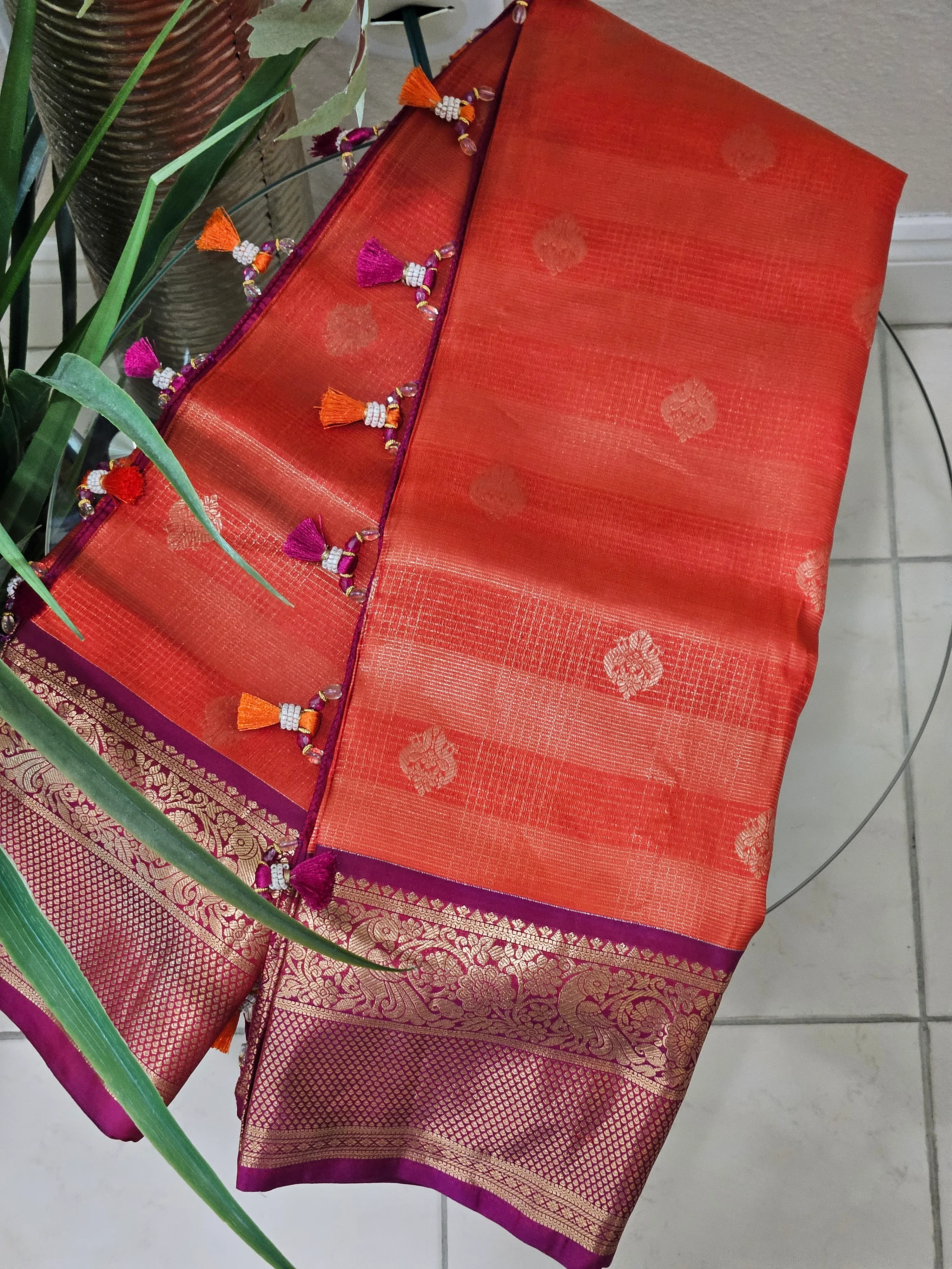 Handwoven pure Kanchipuram silk wedding saree in vibrant orange with gold and silver zari motifs and rich purple border