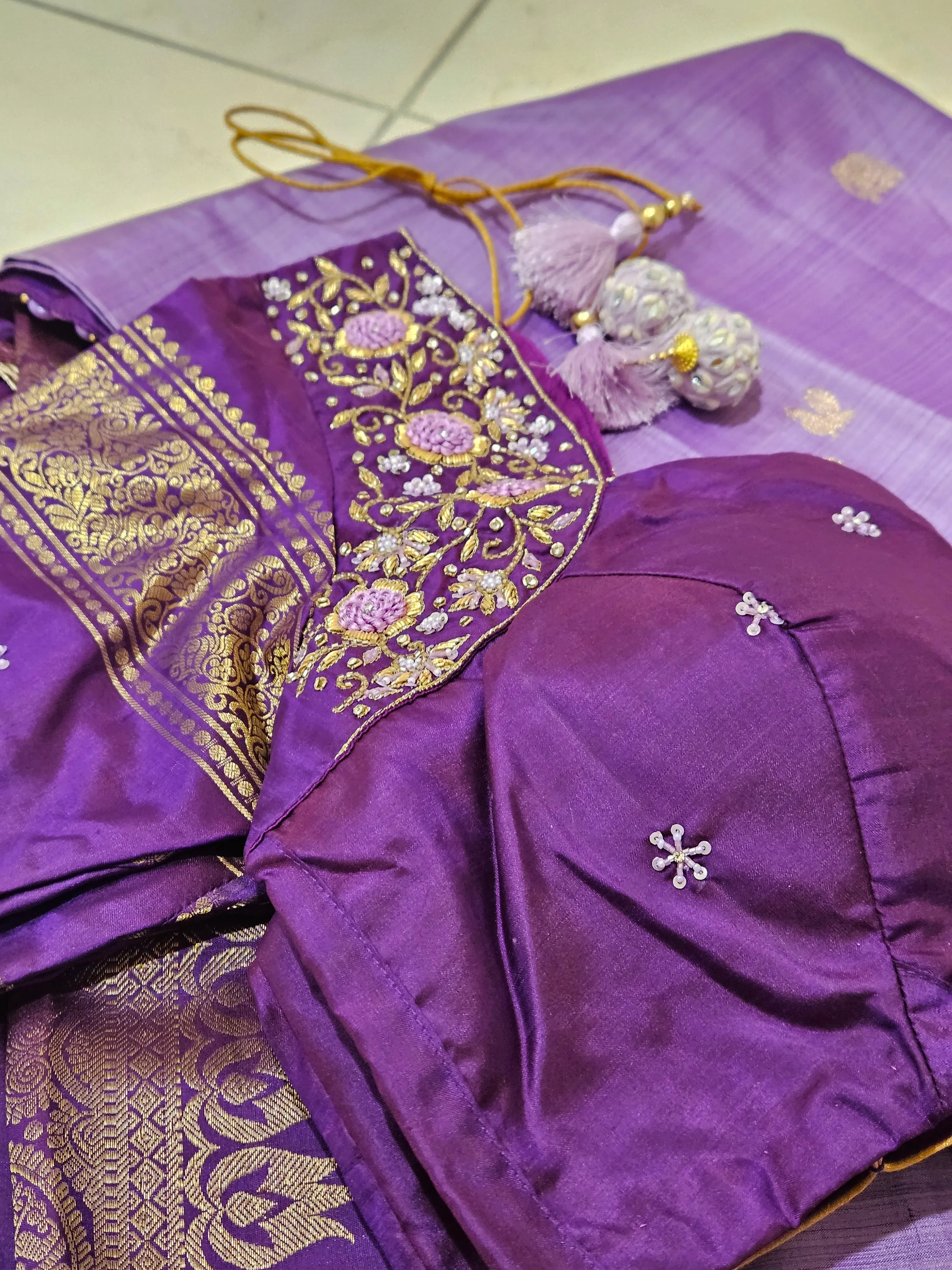 Pure Kanchipuram silk saree in rich purple with intricate gold and silver zari work, paired with matching blouse and tassels.