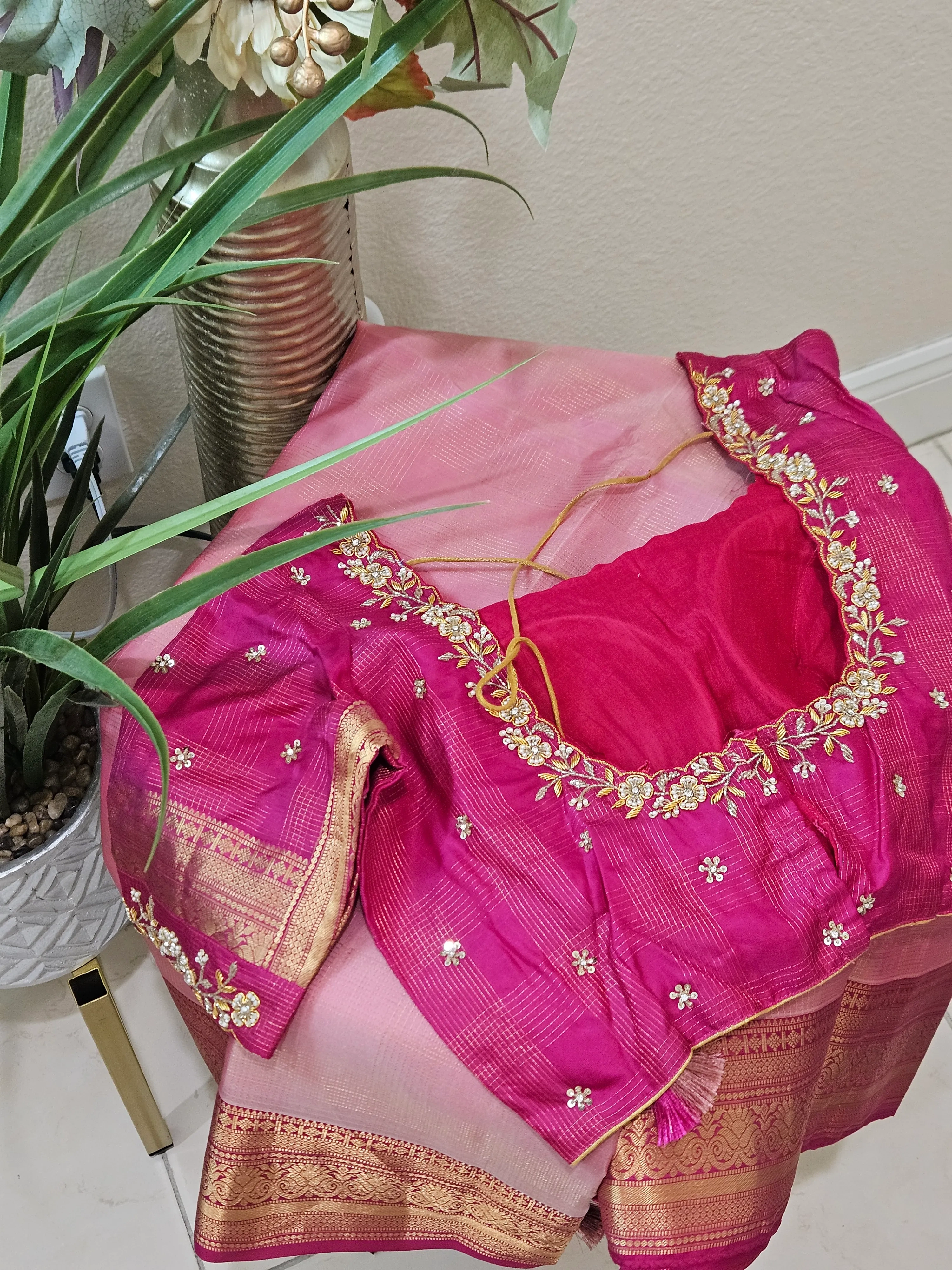 Pure handwoven Kanchipuram silk saree in gold with intricate zari border, paired with a pink embroidered blouse, ideal for weddings.