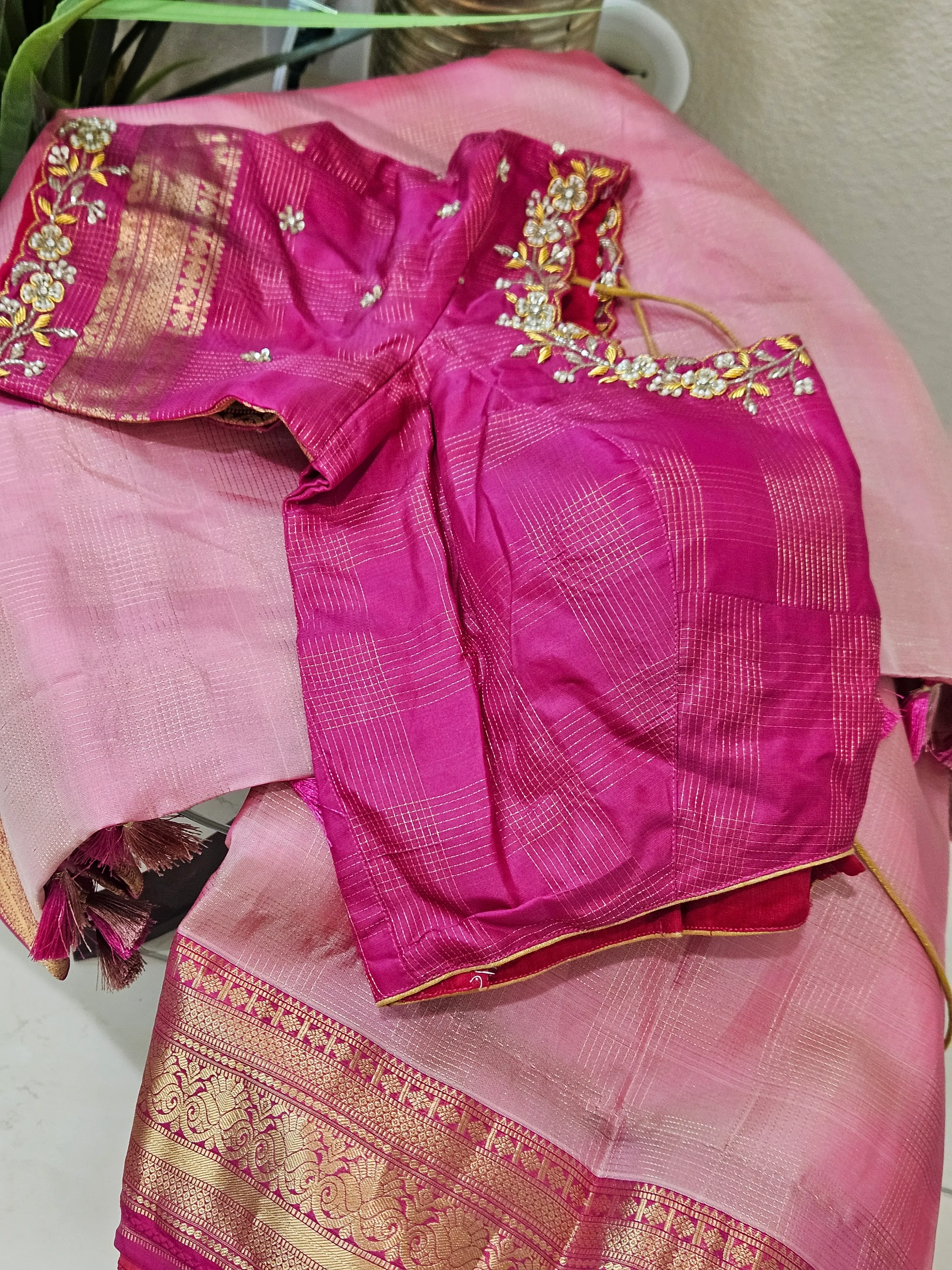 Pure handwoven Kanchipuram silk saree in gold with intricate zari border, paired with a pink embroidered blouse.