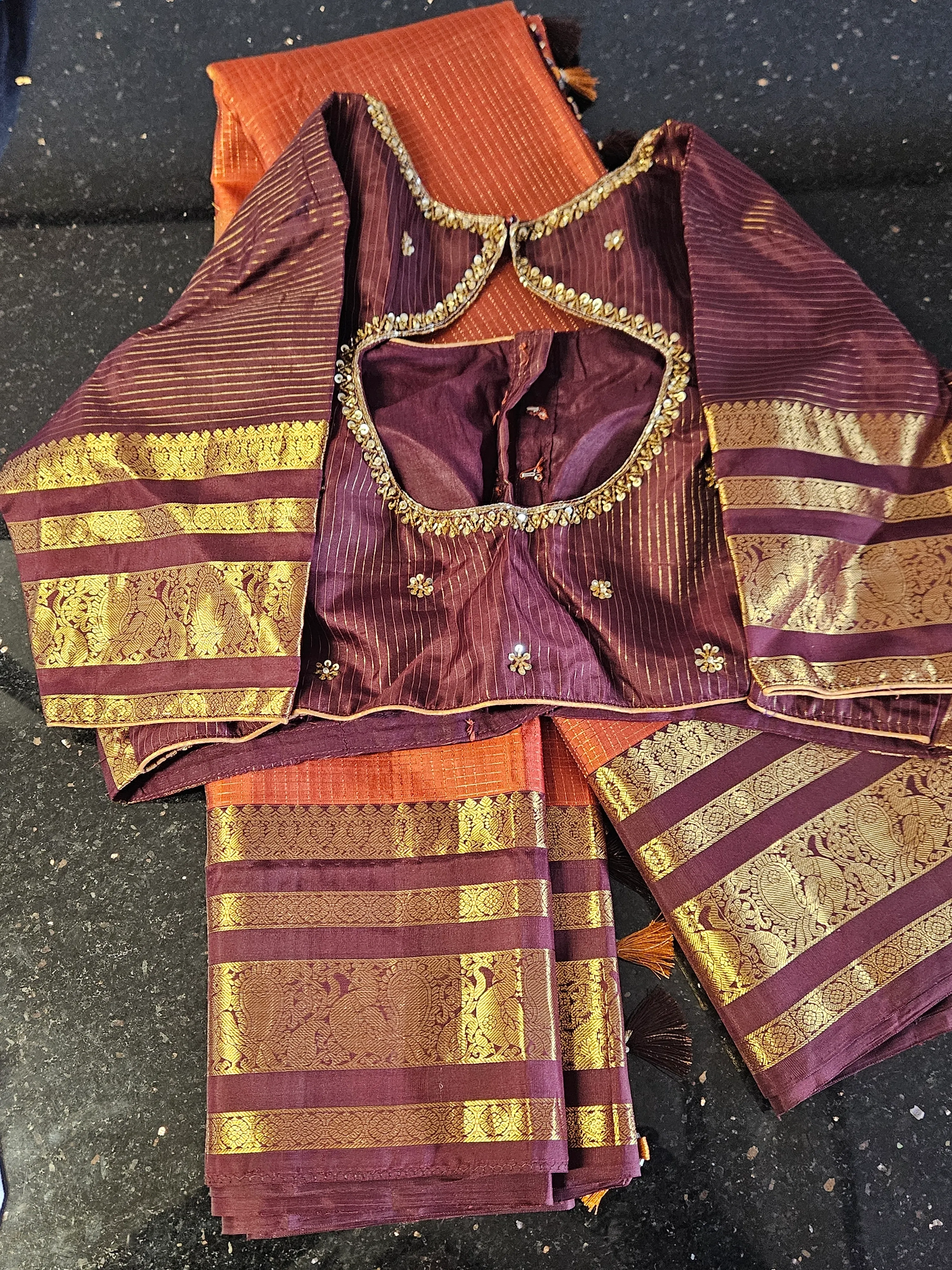 Handwoven Kanchipuram silk saree in deep maroon with rich gold zari borders, paired with a matching embroidered blouse.