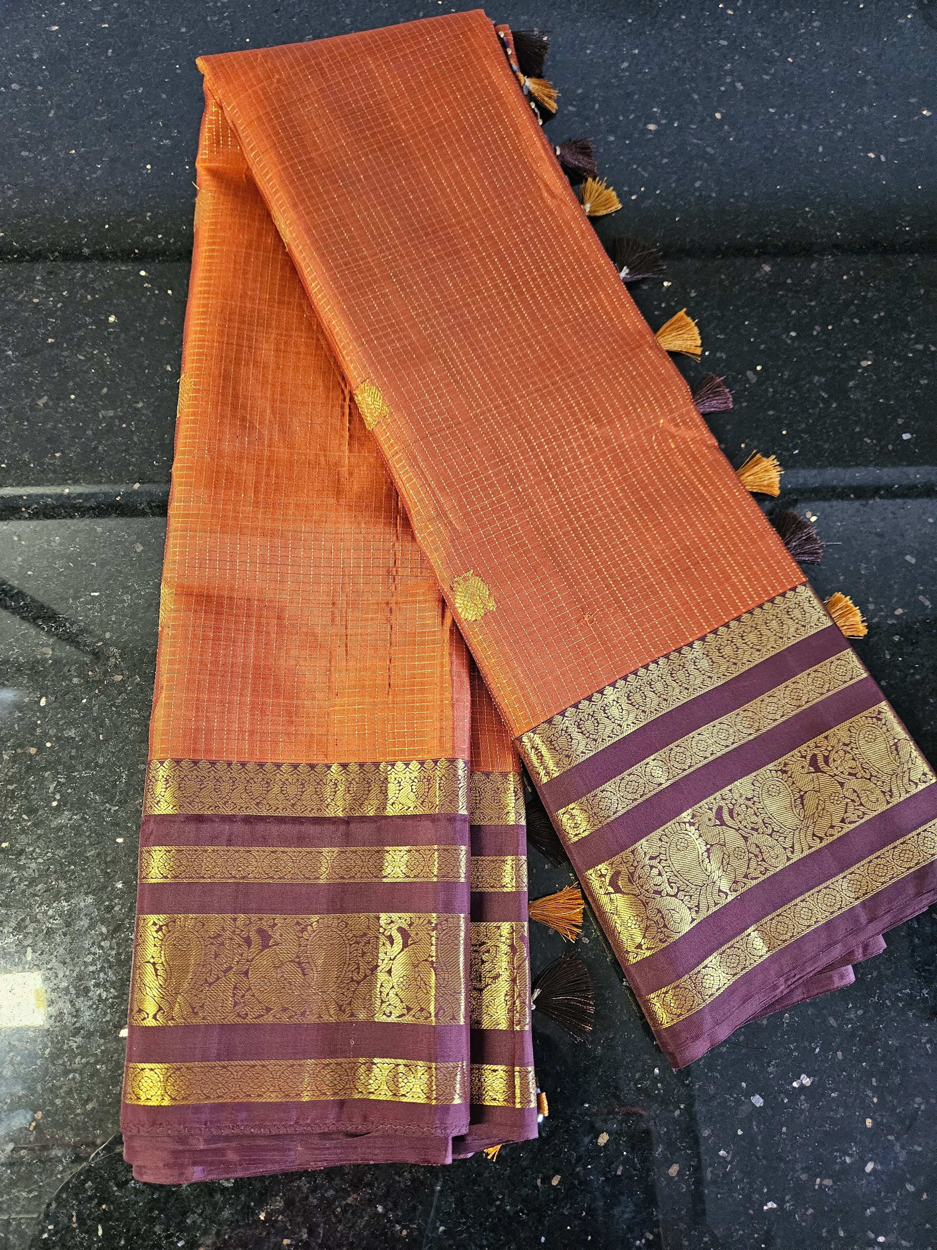 Handwoven Kanchipuram silk saree in rich orange with gold zari motifs and intricate gold borders, ideal for weddings.