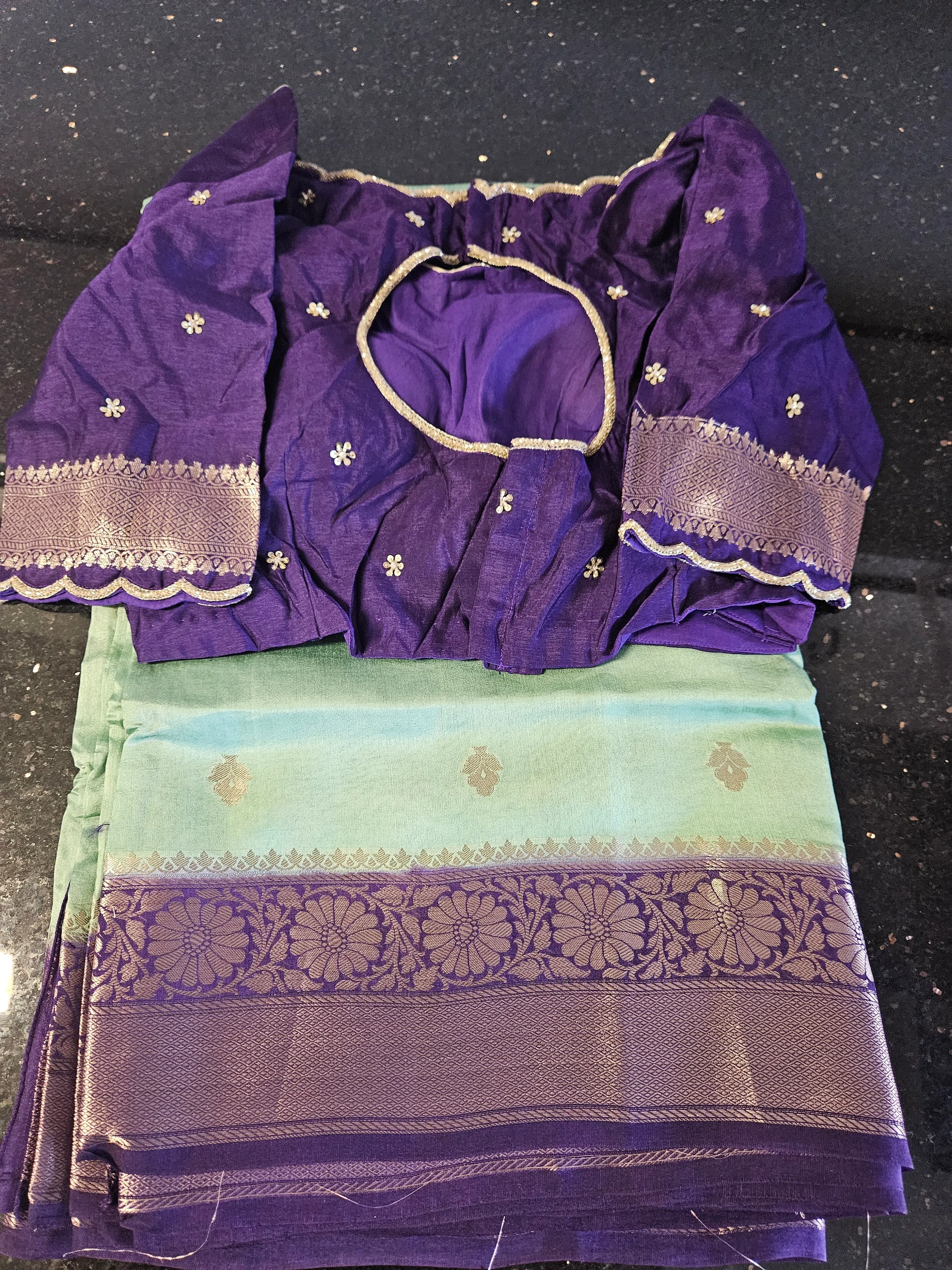 Handwoven pure Banarasi Kora tissue silk saree in green and purple with gold zari floral border, paired with a purple blouse.