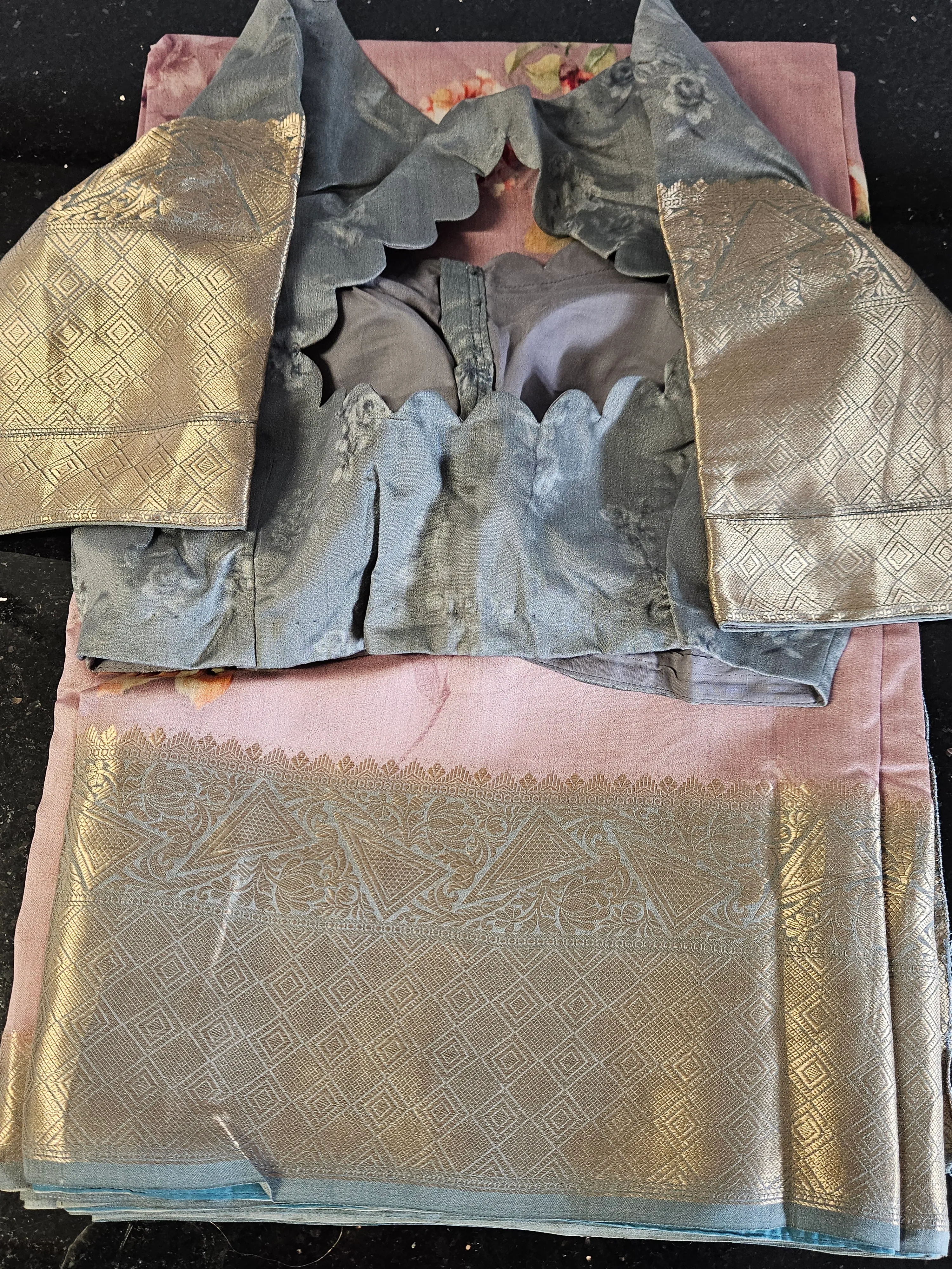 Handwoven Banarasi silk saree in soft pink with gold zari floral motifs, paired with a blue and gold brocade blouse.
