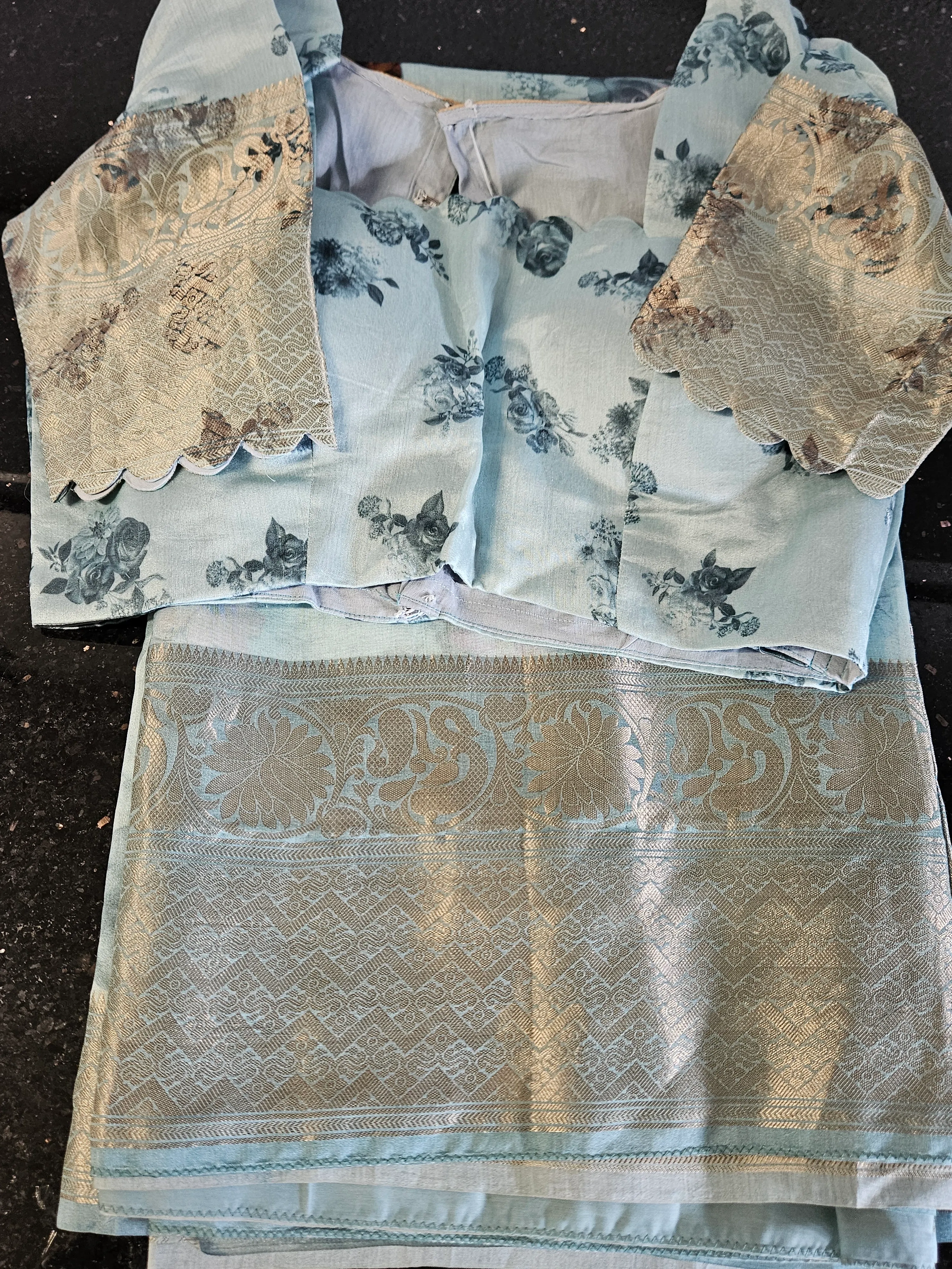 Handwoven pure Banarasi silk saree in pastel blue with intricate silver zari floral motifs and matching blouse piece.