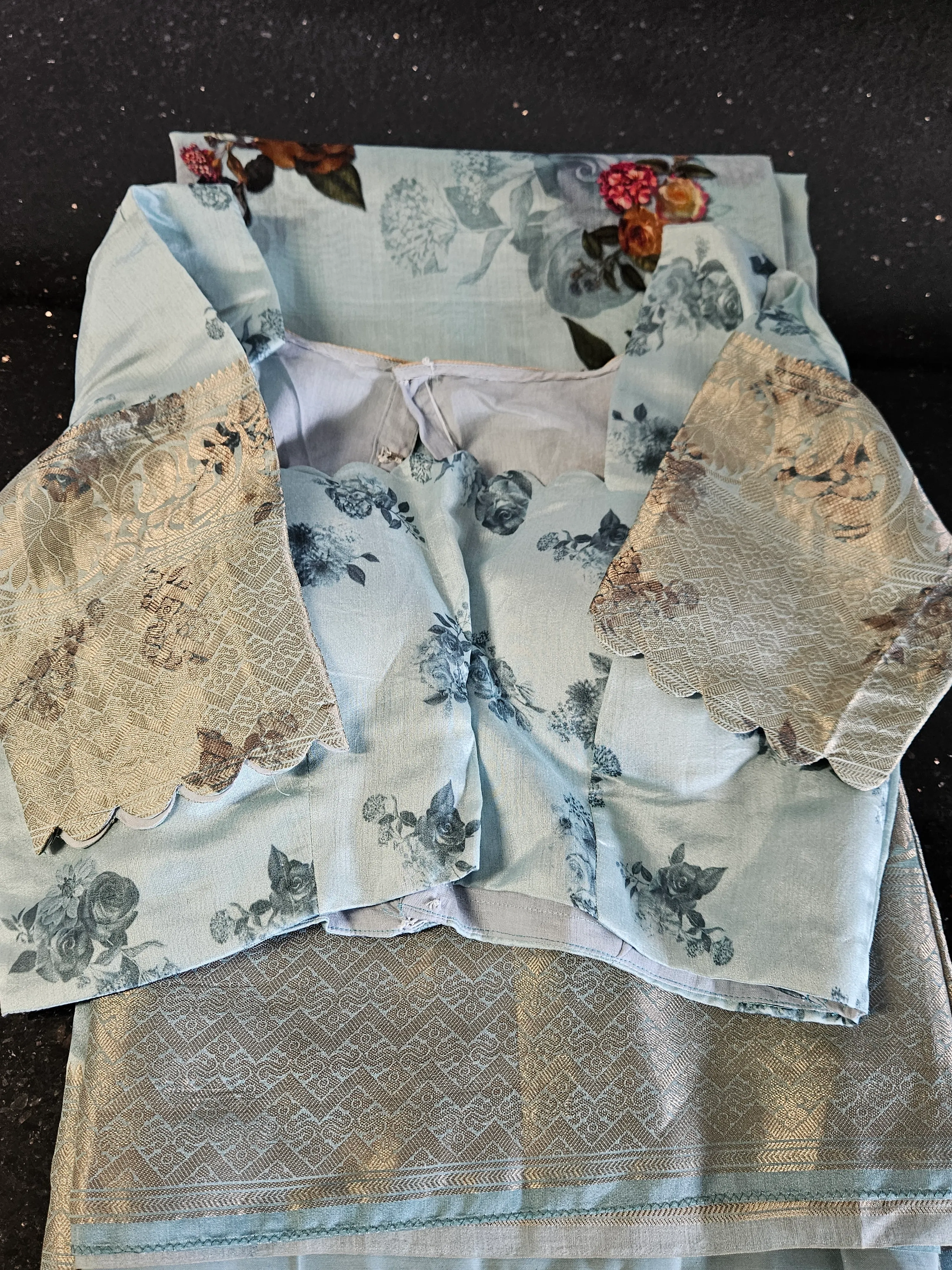 Handwoven pure Banarasi silk saree in soft blue with multicolor floral zari motifs and intricate gold border detailing.