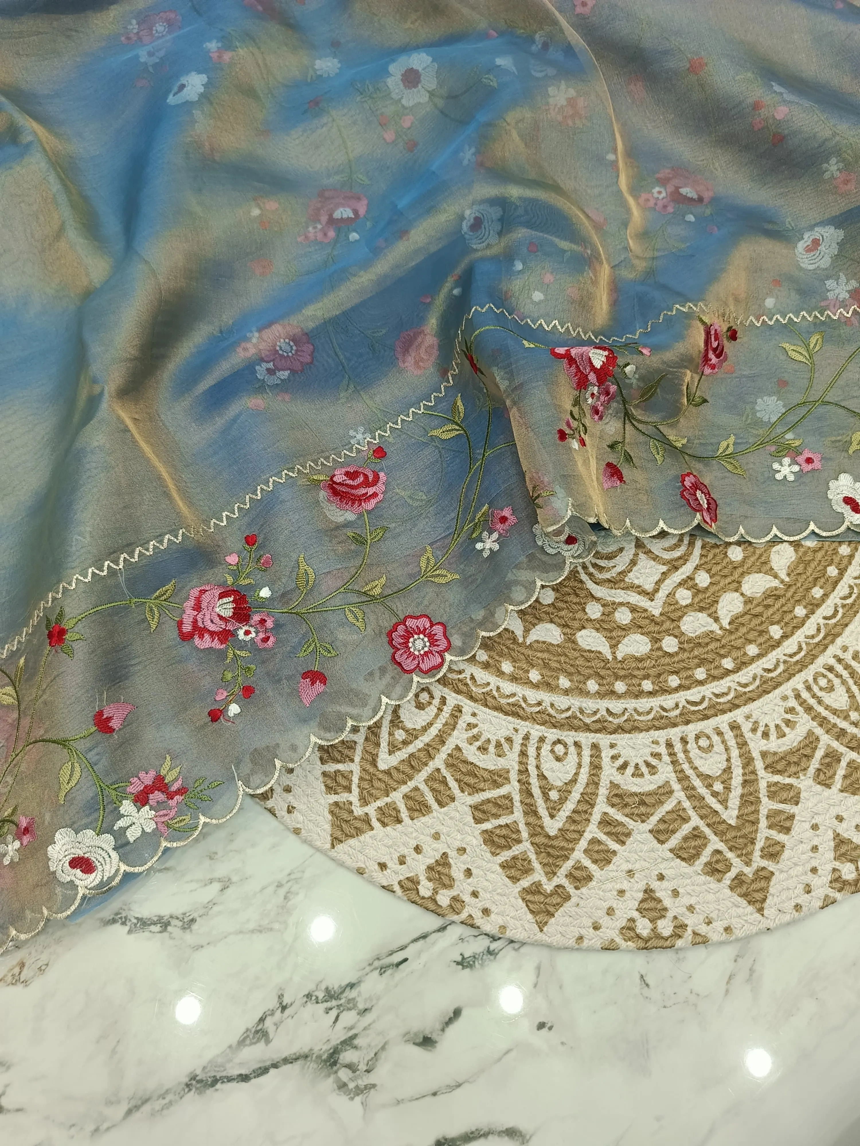 Handwoven Banarasi tissue silk saree in blue with gold and silver zari, floral embroidery, and scalloped border.