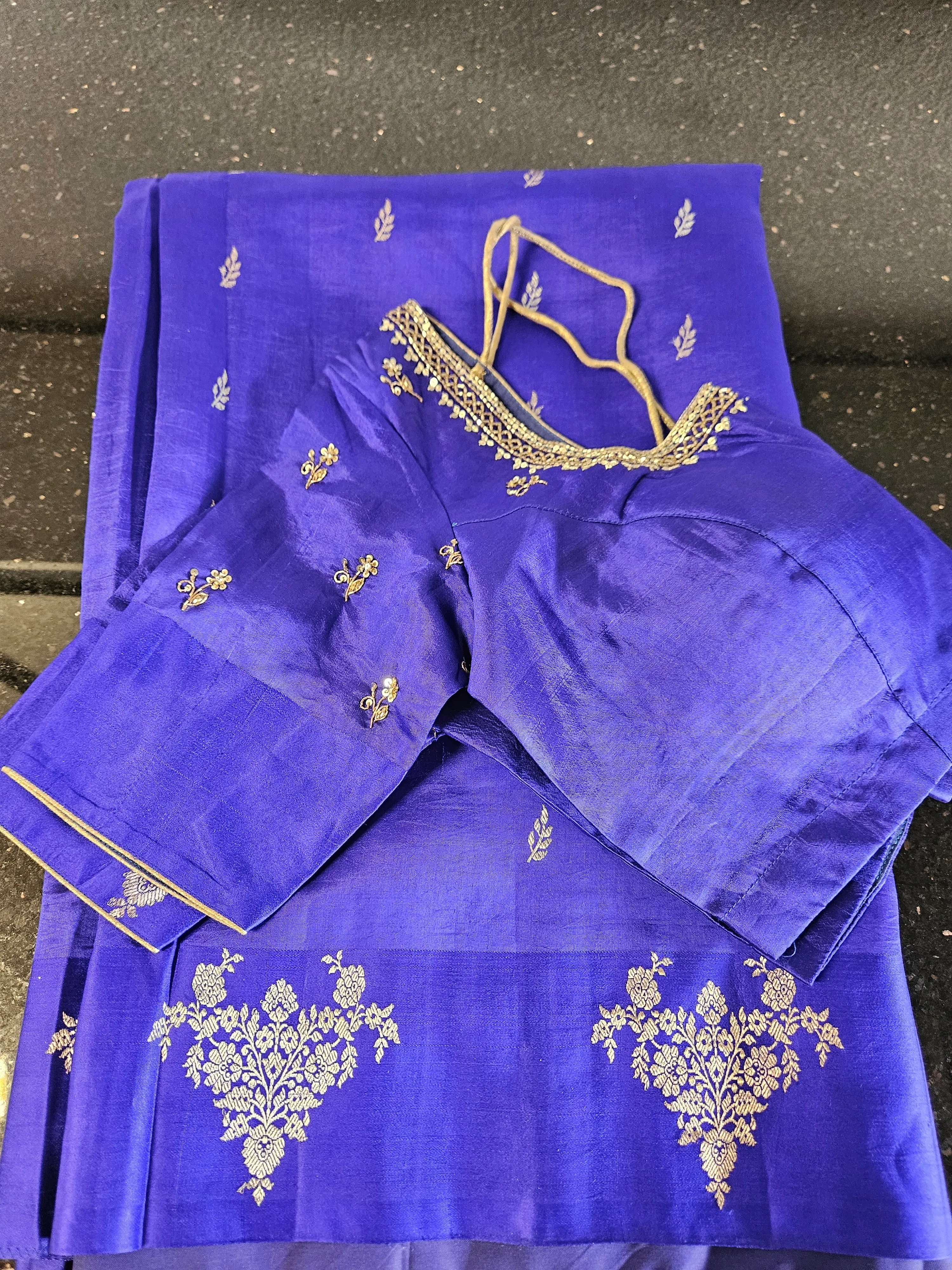 Royal blue handloom pattu silk saree with gold zari floral motifs, paired with matching embroidered blouse piece.
