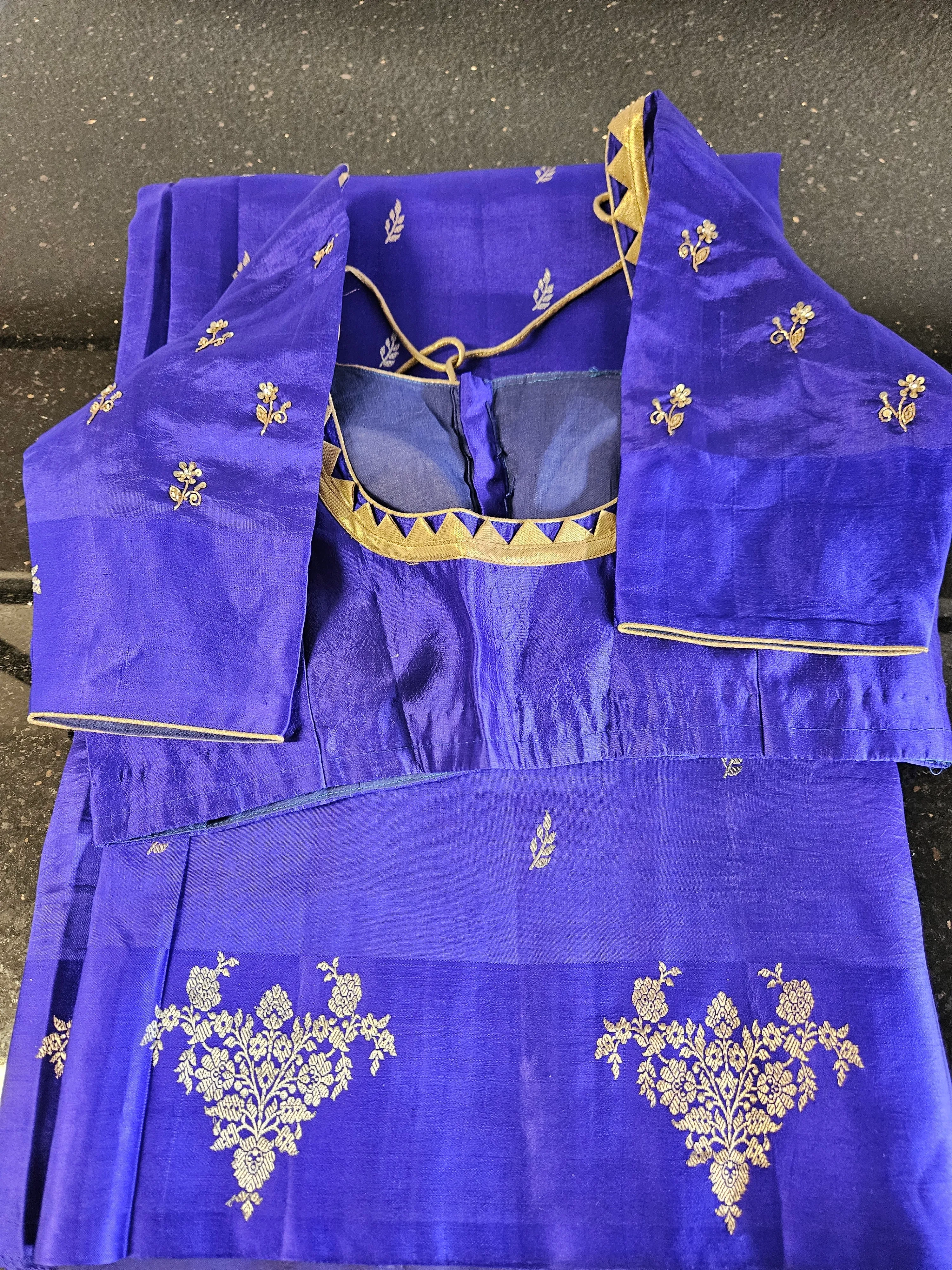 Royal blue handloom pattu silk saree with gold zari floral motifs, paired with matching blouse featuring gold trim.