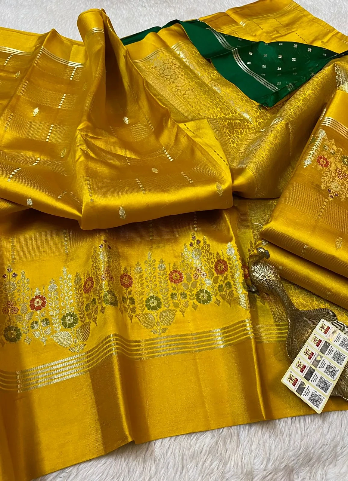 Pure handloom raw mango yellow silk pattu saree with floral zari border and contrasting green pallu, ideal for weddings.