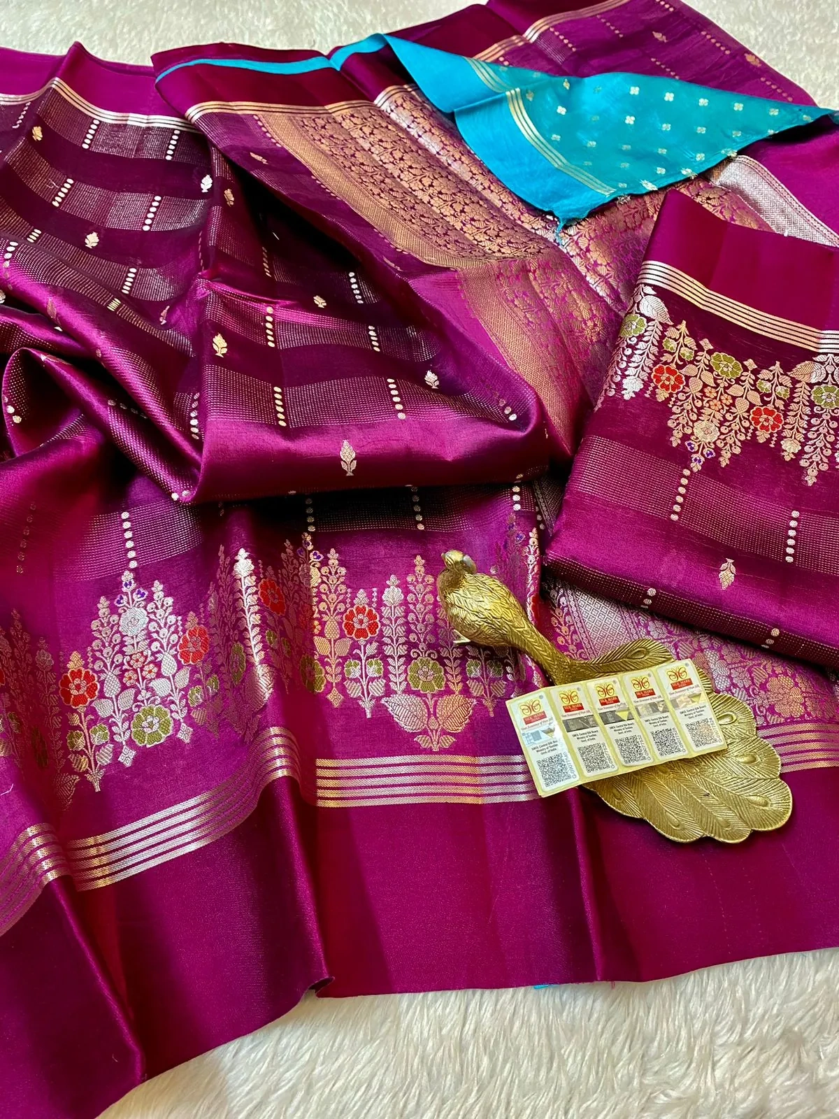 Pure handloom raw mango yellow silk pattu saree with rich magenta base, gold zari floral motifs, and contrasting blue pallu.