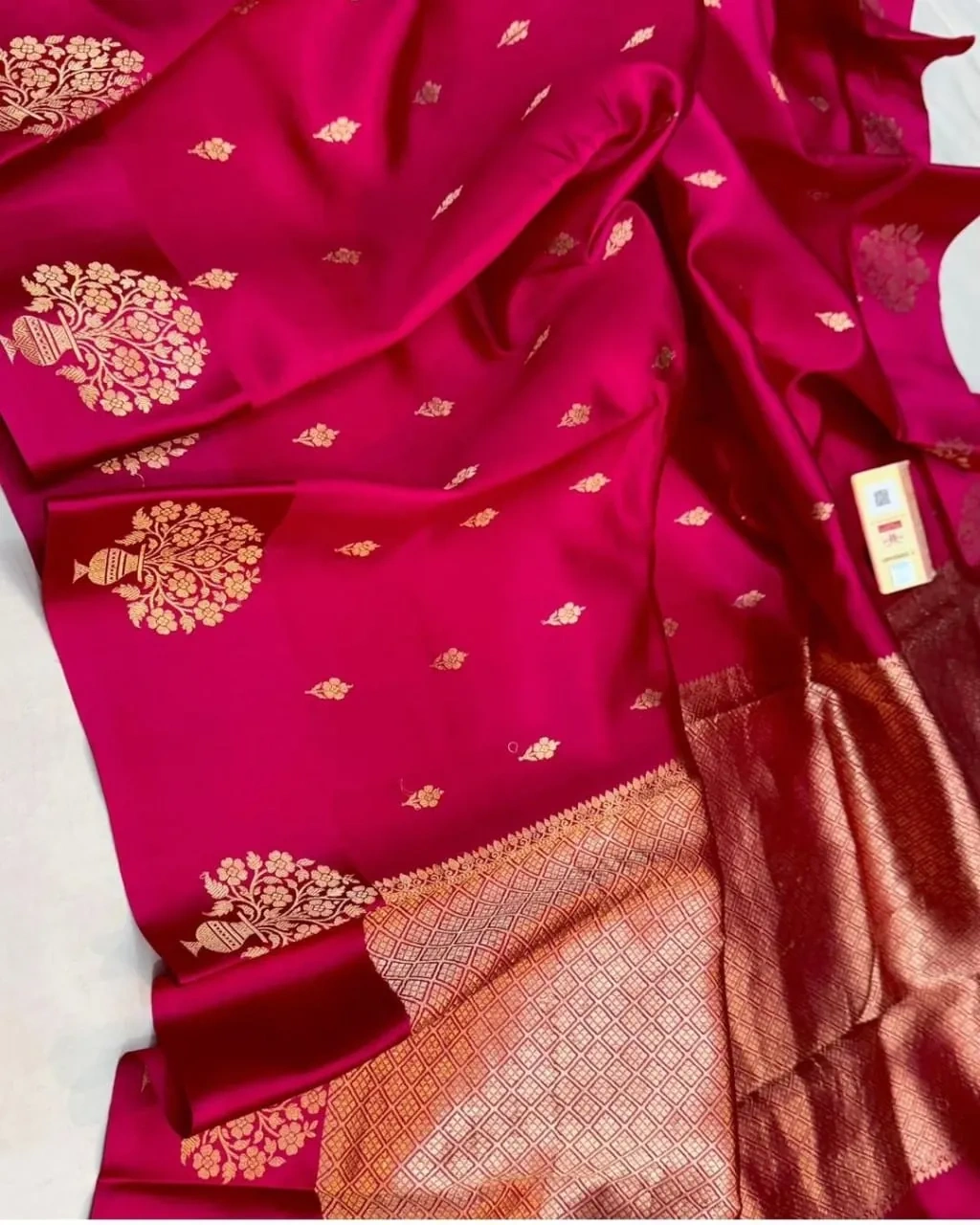 Handwoven pure silk pattu saree in deep magenta with gold zari floral motifs and intricate gold border, ideal for weddings.