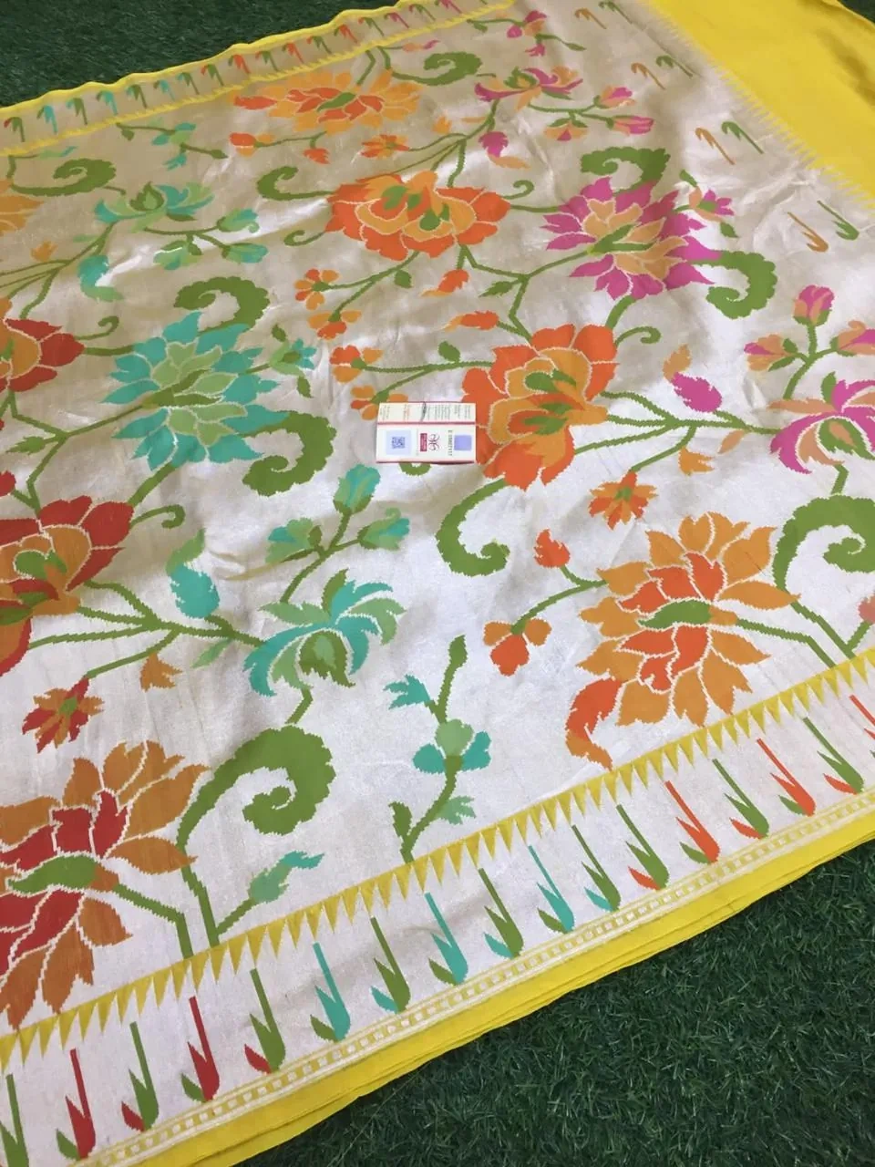 Pure Tussar silk georgette saree in beige with vibrant floral patterns in orange, green, and pink, yellow border