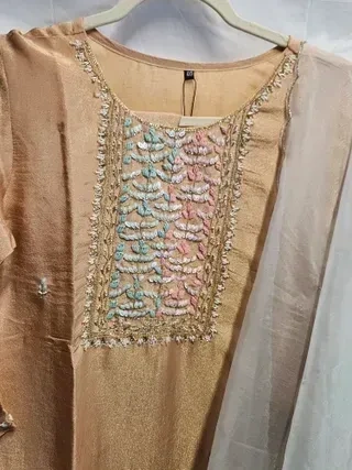 Handcrafted pure tissue silk gown in gold with pastel floral embroidery on the bodice, sheer dupatta, perfect for weddings.