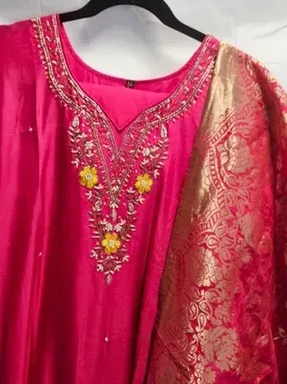 Pure Dola silk maroon Indian dress with intricate golden embroidery and floral accents, paired with a gold brocade dupatta.