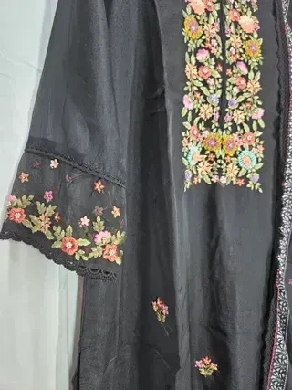 Handcrafted pure muslin lehenga in deep earthy tones with vibrant floral embroidery and lace-trimmed sleeves, ideal for weddings.