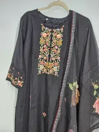 Handcrafted pure muslin lehenga in earthy grey tones with floral embroidery and printed dupatta, ideal for festive wear.