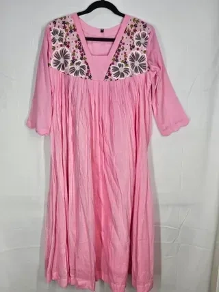Blush pink mul cotton midi dress with charcoal grey floral embroidery on the yoke, featuring three-quarter sleeves.