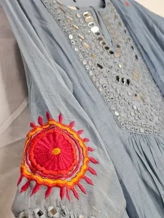 Pastel blue Chanderi silk suit set with mirror work on the bodice and vibrant red-orange embroidered sleeve detail.
