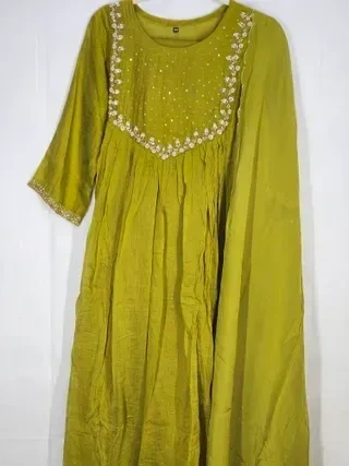 Hand-embroidered beige mul Chanderi silk suit with delicate floral detailing, ideal for weddings and festive occasions.