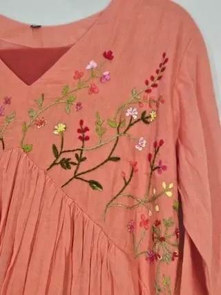 Handcrafted pastel pink mul cotton kurta with floral embroidery, V-neckline, and pleated detailing, perfect for festive wear
