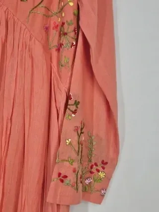 Handcrafted pastel pink mul cotton kurta set featuring delicate floral embroidery on the sleeve and bodice, festive Indian wear.