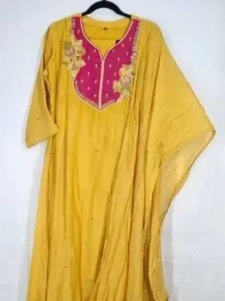 Mustard yellow Chanderi silk suit with gold embroidery, hot pink yoke, and festive detailing, ideal for special occasions.