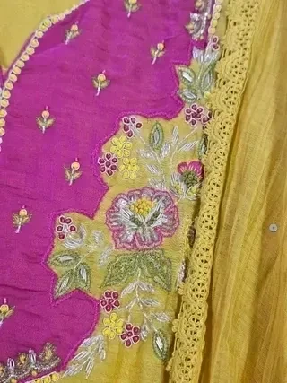 Mustard yellow Chanderi silk suit with gold embroidery, hot pink accents, and floral threadwork, ideal for festive wear