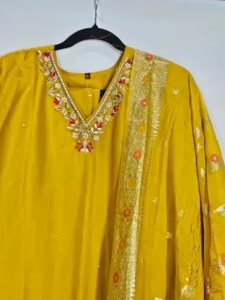 Pure Dola silk Indian gown in mustard yellow with intricate floral embroidery and gold detailing, ideal for weddings and festivals.
