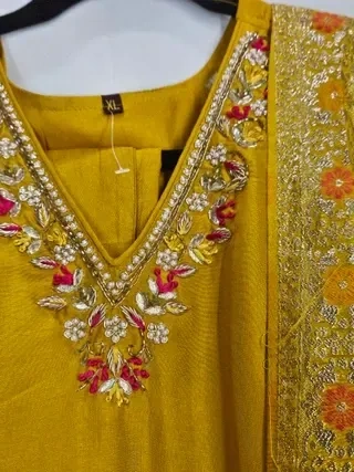 Pure Dola silk Indian gown in mustard yellow with floral embroidery, gold zari work, and pink accent details, perfect for weddings.