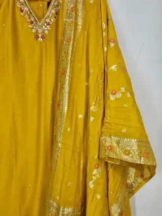 Pure Dola silk Indian gown in mustard yellow with gold embroidery, floral accents, and matching dupatta for festive wear