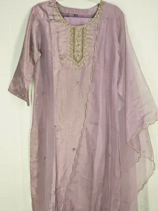 Handcrafted pure tissue silk gown in soft lavender with gold embroidered neckline, sheer sleeves, perfect for Indian weddings.