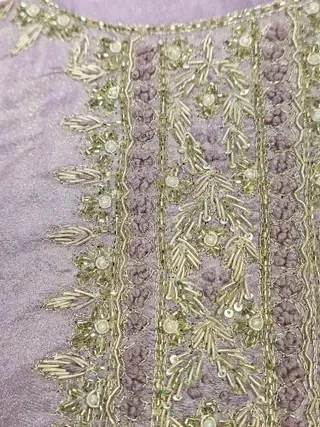 Handcrafted pure tissue silk gown in soft lavender with intricate gold zari embroidery and sequin detailing, ideal for weddings.