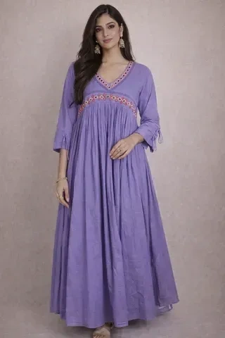 Woman wearing a handcrafted mul cotton ethnic frock dress in lavender with embroidered neckline, ideal for festivals or weddings