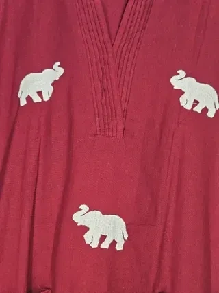 Handcrafted mul cotton ethnic frock in deep red with white embroidered elephant motifs and pleated V-neck detailing.