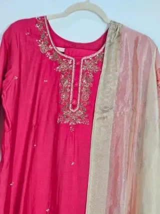 Ivory muslin Anarkali gown with intricate gold embroidery on the neckline, paired with a sheer ivory dupatta.