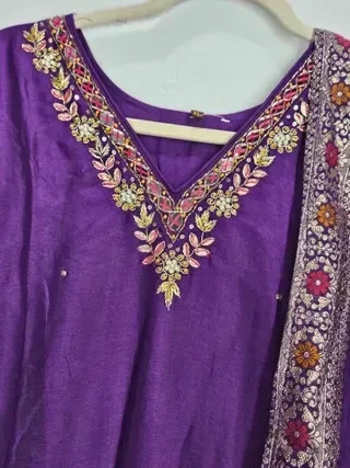 Jewel-toned purple pure Dola silk gown with intricate floral embroidery on the neckline, paired with a matching dupatta.
