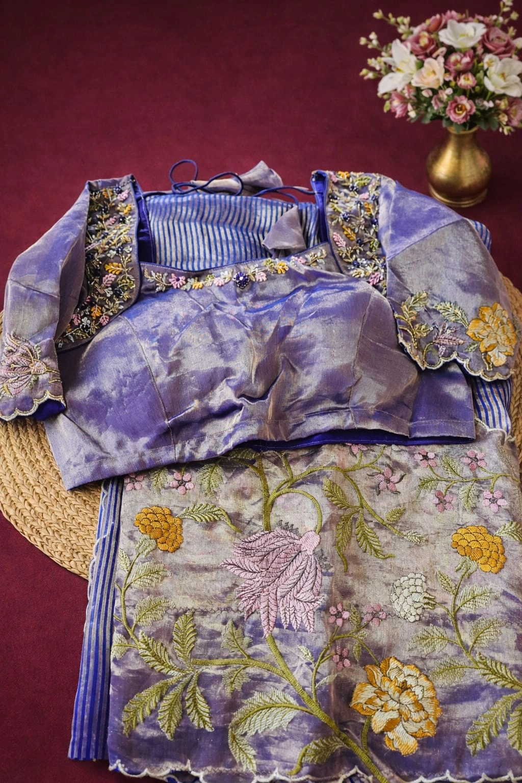 Handwoven Banarasi Kora tissue saree in gold and silver tones with floral embroidery, paired with a purple blouse on display.